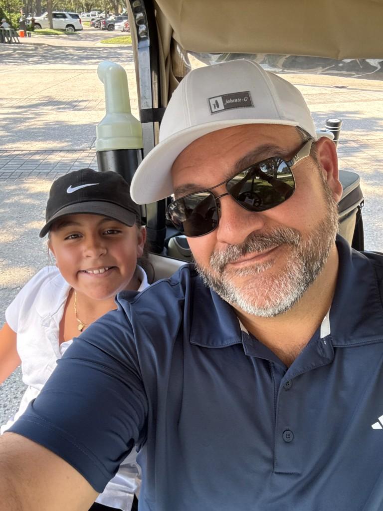 Alex in a golf cart with family